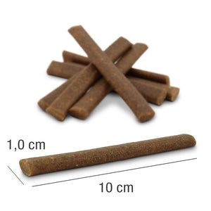 PLATINUM Fit-Sticks Chicken + Lamb 300g, Fit priboljški za Pse je zloženih na beli površini. En priboljšek leži spredaj in kaže svojo velikost: debelina 1,0 cm in dolžina 10 cm.